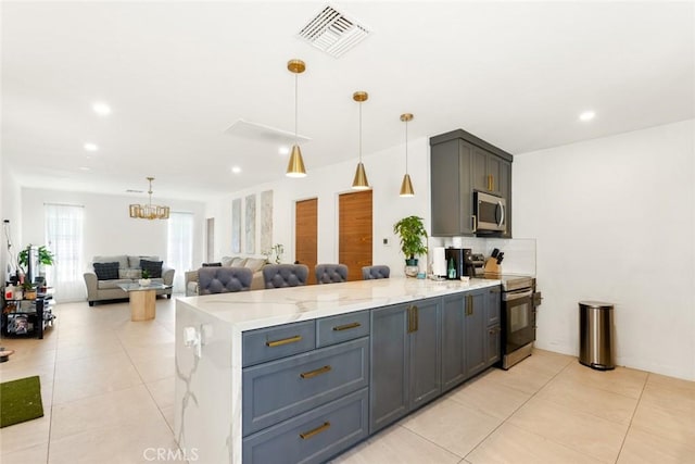 kitchen with pendant lighting, stainless steel appliances, gray cabinets, and light stone counters