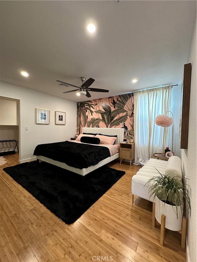 bedroom featuring a textured ceiling, light hardwood / wood-style floors, and ceiling fan