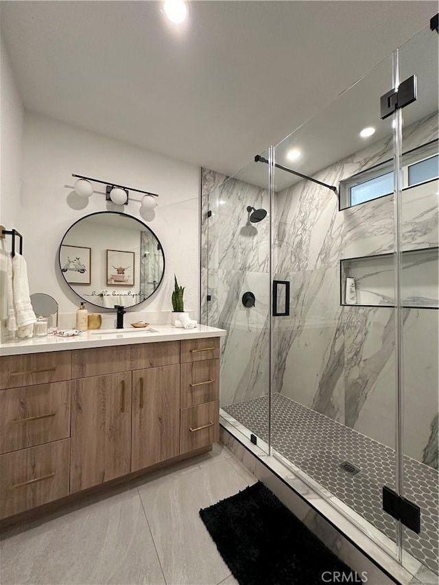 bathroom featuring vanity and a shower with door