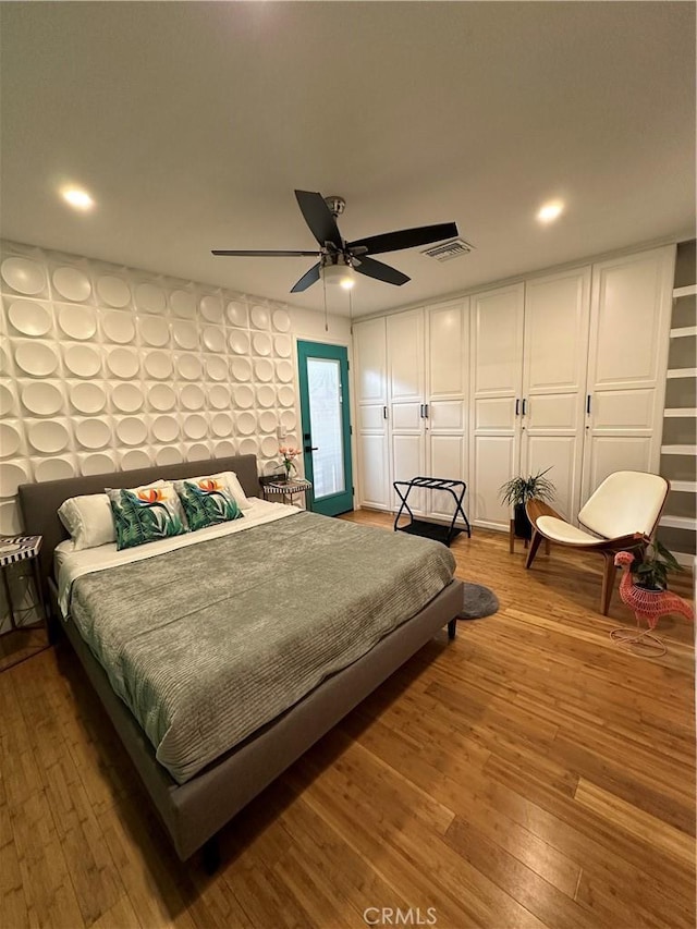 bedroom featuring hardwood / wood-style floors, ceiling fan, and a closet