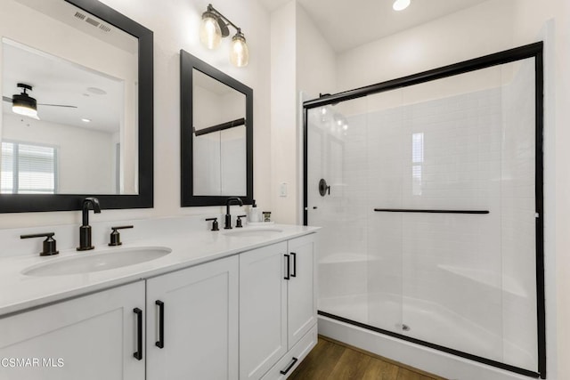 bathroom with hardwood / wood-style flooring, ceiling fan, an enclosed shower, and vanity