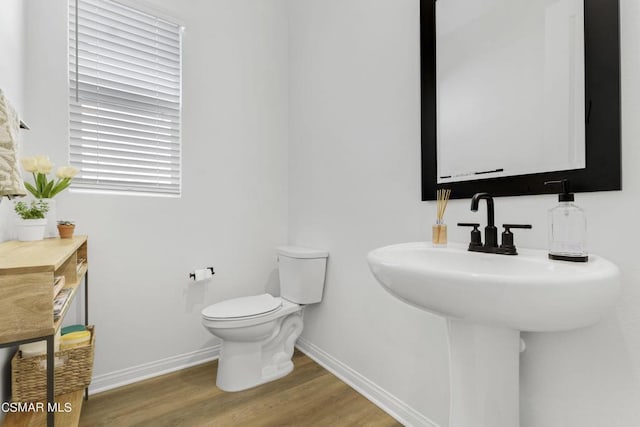 bathroom with plenty of natural light, toilet, wood-type flooring, and sink