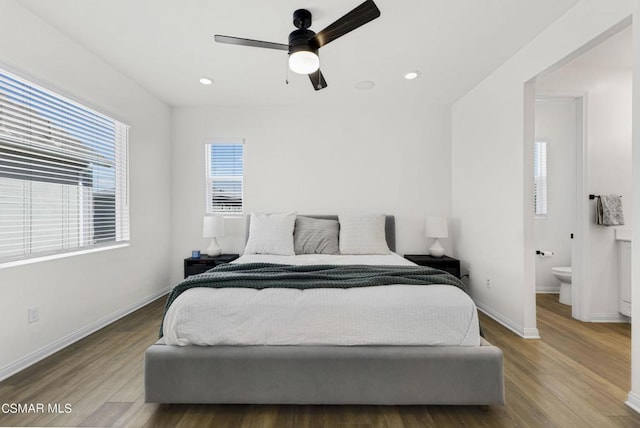 bedroom featuring hardwood / wood-style floors, ceiling fan, and connected bathroom