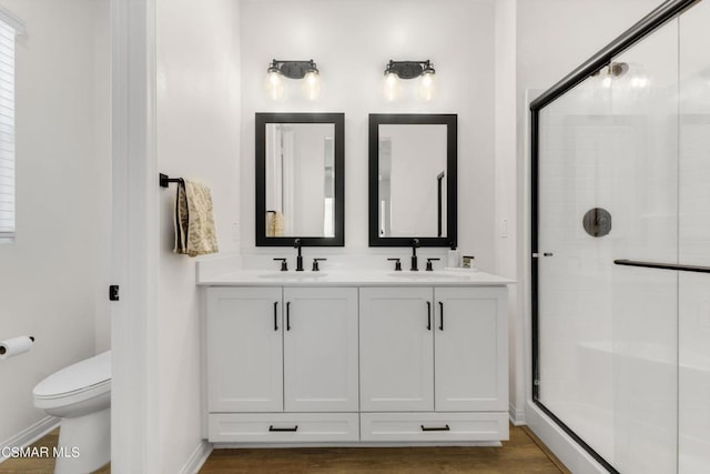 bathroom featuring walk in shower, hardwood / wood-style floors, vanity, and toilet