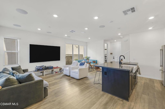 living room with light hardwood / wood-style flooring and sink