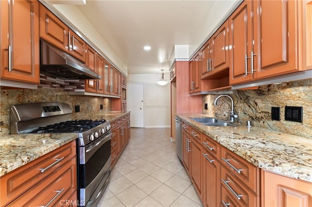 kitchen featuring light stone countertops, appliances with stainless steel finishes, backsplash, and sink