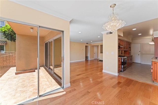 empty room with light hardwood / wood-style flooring and a chandelier