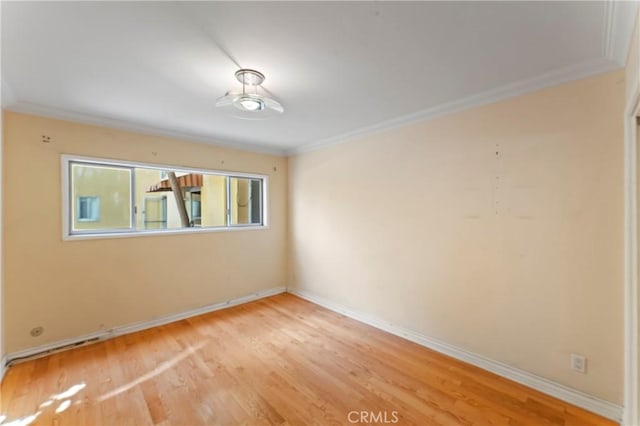 spare room featuring light hardwood / wood-style floors and crown molding