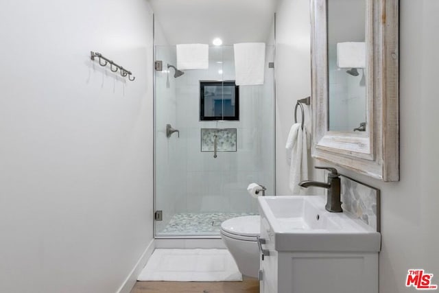 bathroom featuring walk in shower, vanity, toilet, and wood-type flooring