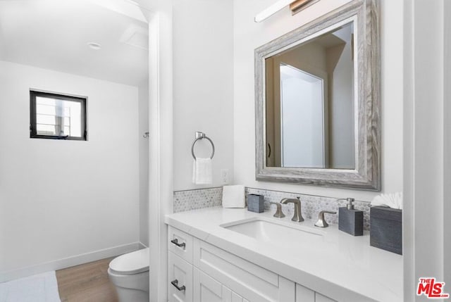 bathroom featuring wood-type flooring, vanity, and toilet