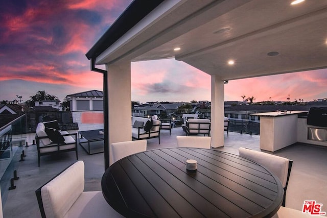 patio terrace at dusk with a balcony and outdoor lounge area