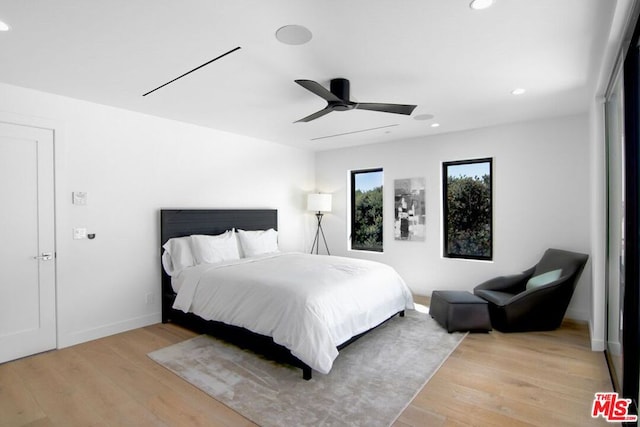 bedroom with ceiling fan and light wood-type flooring