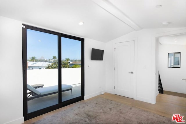 interior space featuring light hardwood / wood-style flooring and vaulted ceiling with beams