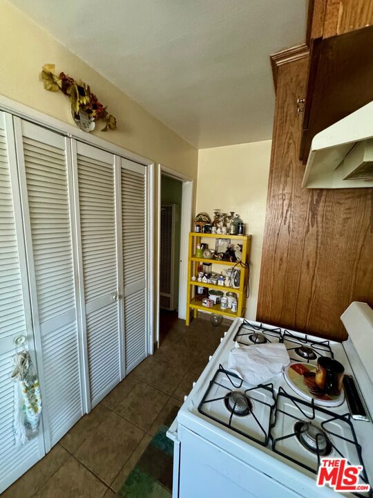 kitchen with dark tile patterned flooring and gas range gas stove