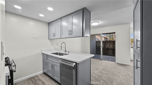 kitchen with gray cabinetry, sink, carpet, appliances with stainless steel finishes, and a textured ceiling