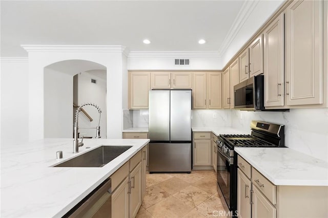 kitchen with crown molding, sink, light stone countertops, and appliances with stainless steel finishes