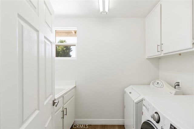 laundry area with dark hardwood / wood-style floors, cabinets, and independent washer and dryer