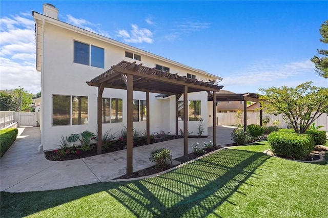 rear view of house featuring a pergola, a lawn, and a patio