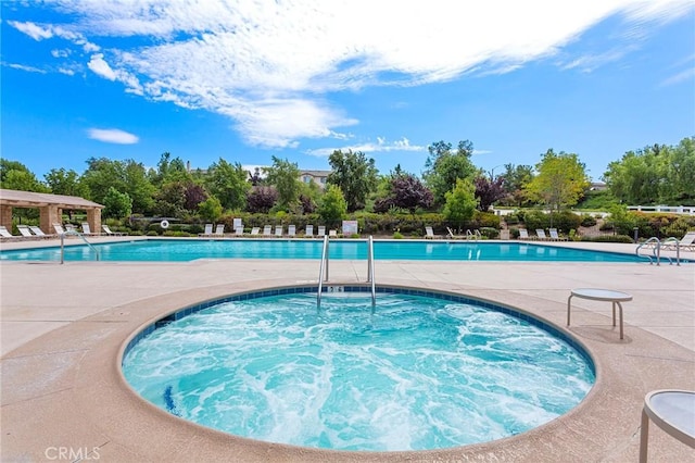 view of swimming pool featuring a hot tub