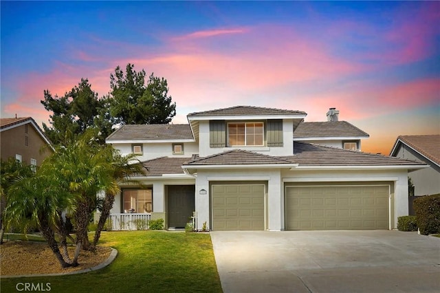 view of front of home featuring a garage and a lawn