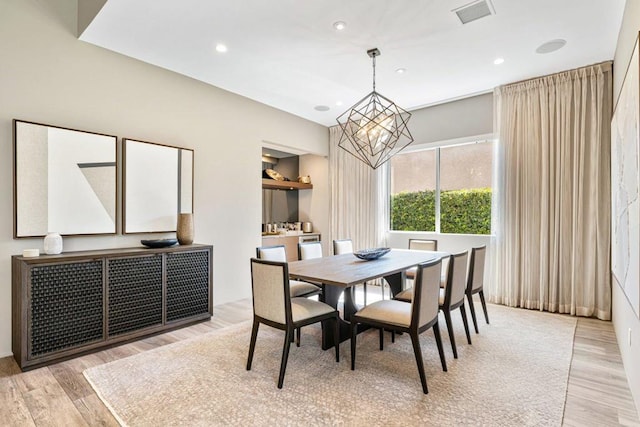 dining area with a chandelier and light hardwood / wood-style floors