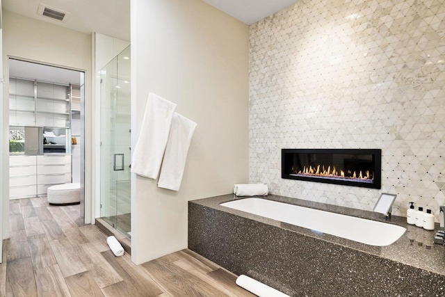 bathroom featuring separate shower and tub and hardwood / wood-style floors