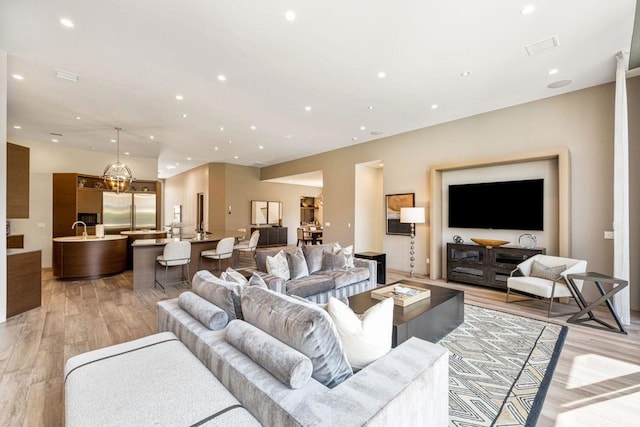 living room featuring sink and light hardwood / wood-style floors