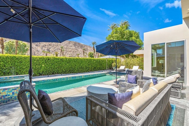 view of pool featuring a mountain view, outdoor lounge area, and a patio area