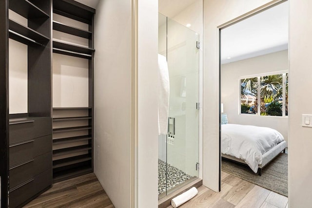 bathroom with hardwood / wood-style floors and an enclosed shower