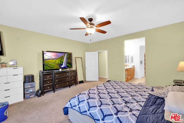 bedroom featuring ensuite bath, ceiling fan, and light colored carpet