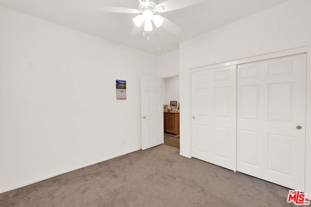 unfurnished bedroom with ceiling fan, light colored carpet, and a closet