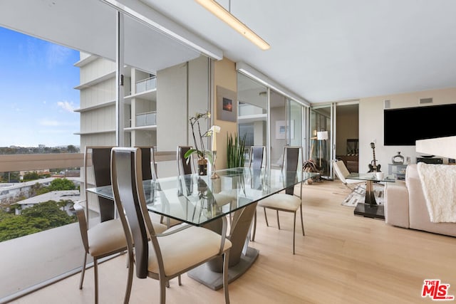 dining room with light hardwood / wood-style flooring and expansive windows