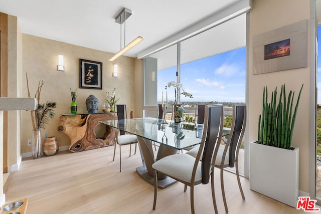 dining room featuring a wall of windows and light hardwood / wood-style flooring