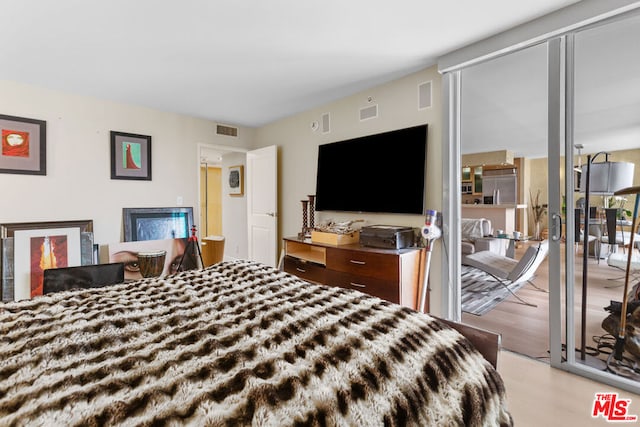 bedroom with light hardwood / wood-style floors and built in fridge