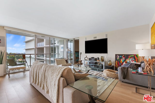 living room with expansive windows and light wood-type flooring