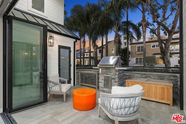 patio terrace at dusk featuring area for grilling and grilling area