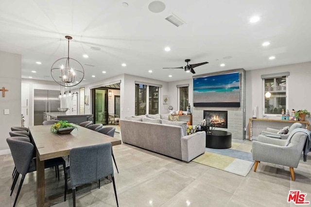 living room featuring ceiling fan with notable chandelier