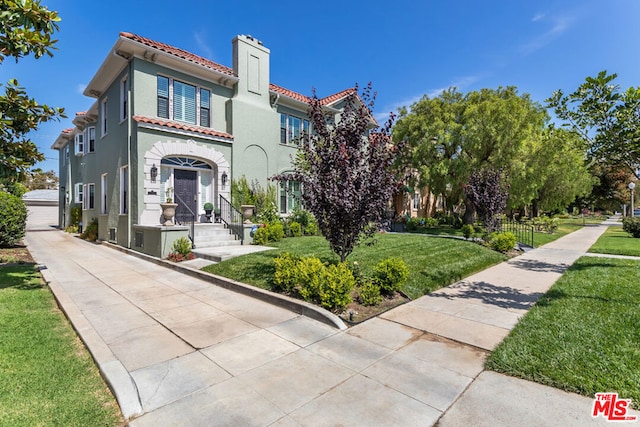 mediterranean / spanish-style house featuring a front yard