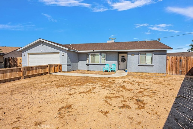 ranch-style house featuring stucco siding, a garage, and fence