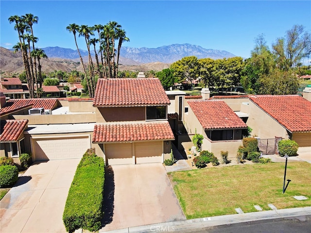 view of front of property featuring a front yard, a mountain view, and a garage