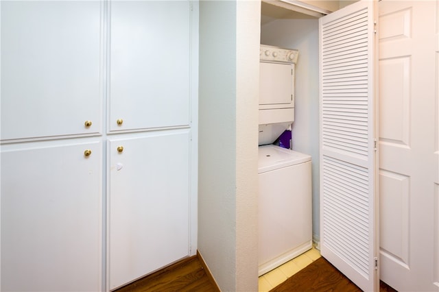 laundry area with stacked washer / dryer and dark hardwood / wood-style floors