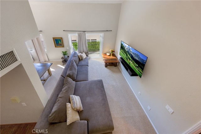 living room with carpet and a towering ceiling