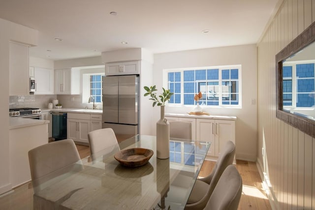 dining area featuring light wood-type flooring and sink