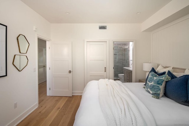 bedroom featuring light hardwood / wood-style floors and connected bathroom