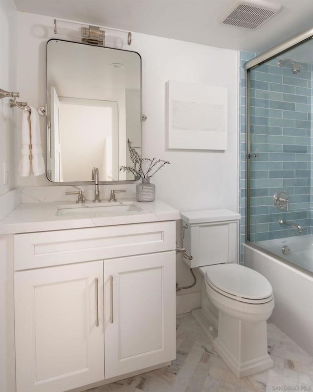 full bathroom featuring combined bath / shower with glass door, vanity, and toilet