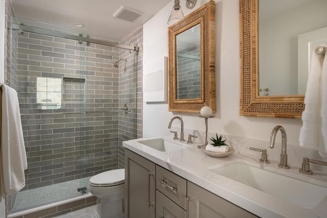 bathroom featuring toilet, vanity, and walk in shower