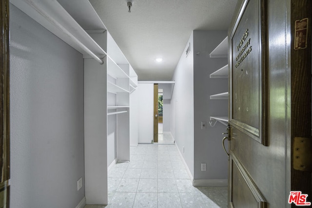 walk in closet featuring light tile patterned flooring