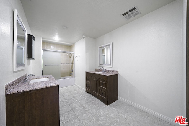 bathroom with vanity and bath / shower combo with glass door