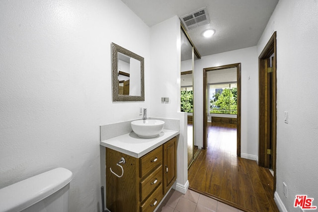 bathroom with vanity, hardwood / wood-style floors, and toilet