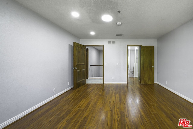 unfurnished bedroom featuring a textured ceiling and dark hardwood / wood-style floors